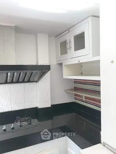 Modern kitchen with sleek black countertops and gas stove