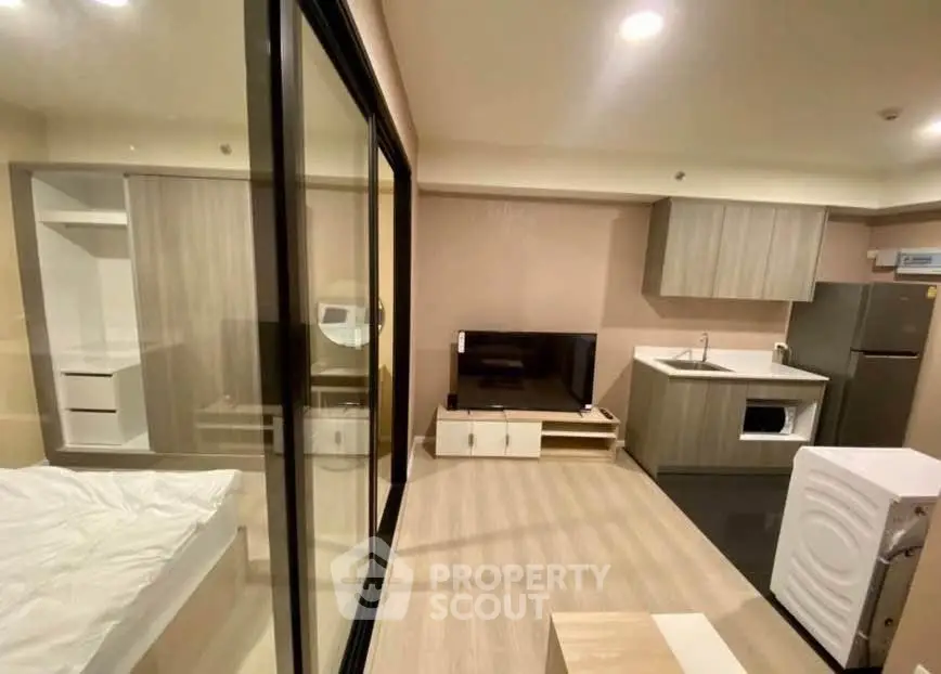 Modern studio apartment with open layout, featuring sleek kitchen and cozy living area.