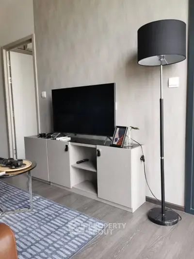 Modern living room with sleek TV stand and floor lamp, perfect for cozy evenings.