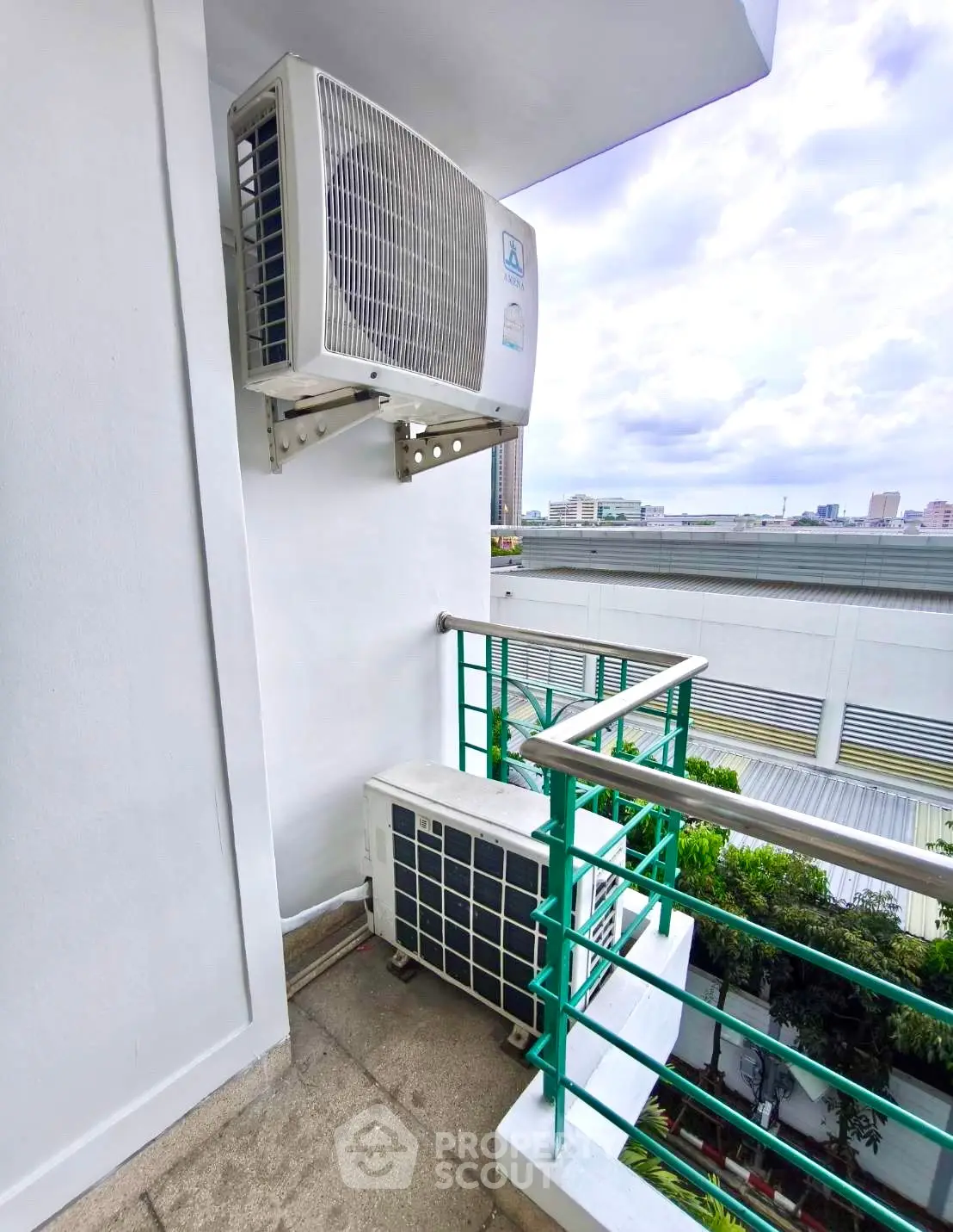 Compact balcony with air conditioning units and city view, ideal for urban living.