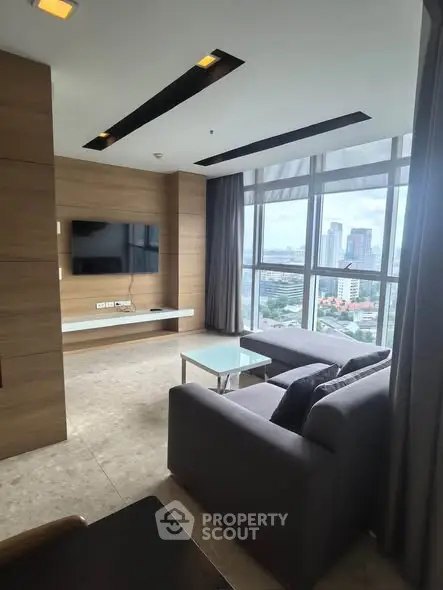 Modern living room with city view, sleek furniture, and large windows.