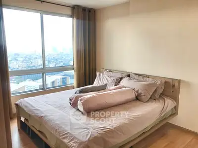 Spacious bedroom with large window offering stunning city views