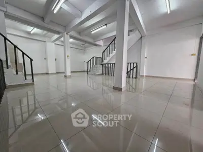 Spacious open-plan interior with polished floors and modern staircase, ideal for versatile use.