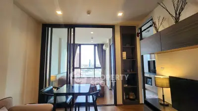 Modern open-plan living room with dining area and bedroom view, featuring stylish decor and natural light.