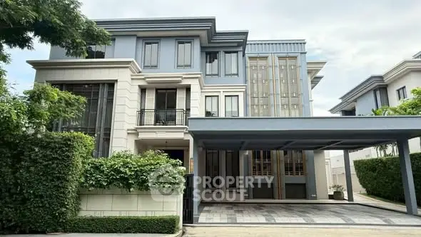 Luxurious modern house with spacious driveway and elegant facade in upscale neighborhood.