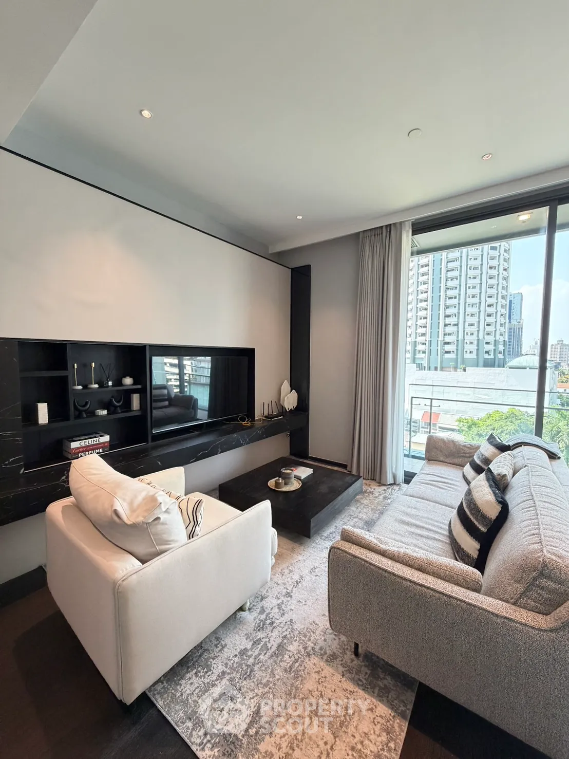 Modern living room with stylish furniture and city view from large window.