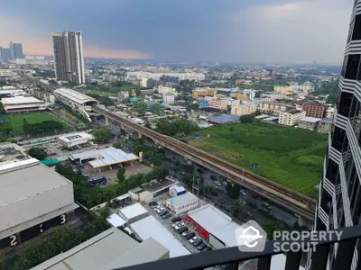 Stunning cityscape view from high-rise balcony overlooking urban skyline and transit lines.