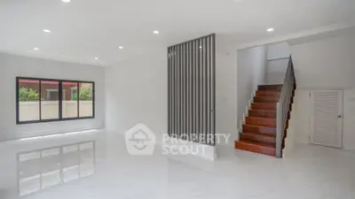 Spacious modern living room with sleek staircase and large windows