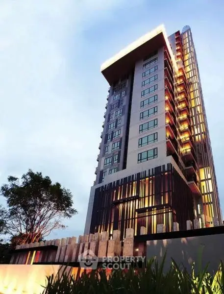 Stunning modern high-rise building with unique architectural design and illuminated facade.