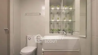 Modern bathroom with sleek fixtures and stylish plant decor, perfect for a contemporary home.