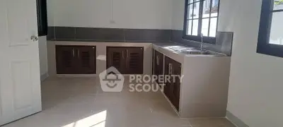 Spacious kitchen with modern cabinetry and large windows for natural light.