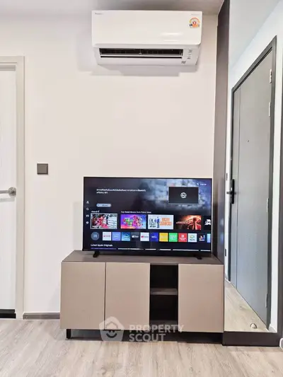 Modern living room with sleek TV setup and air conditioning unit, perfect for comfortable living.