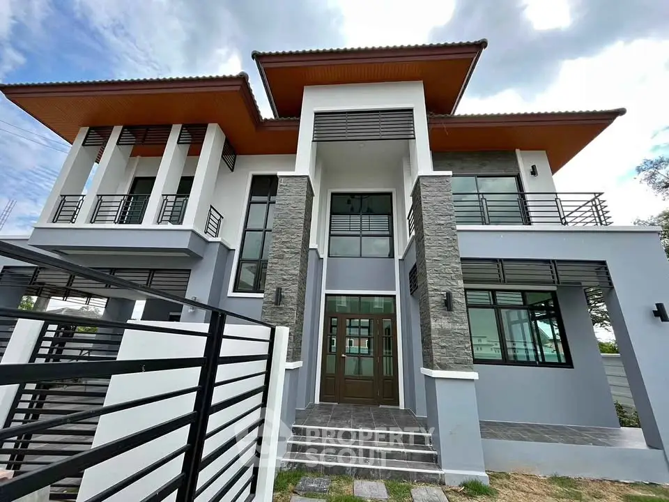 Modern two-story house with unique architectural design and spacious balconies.
