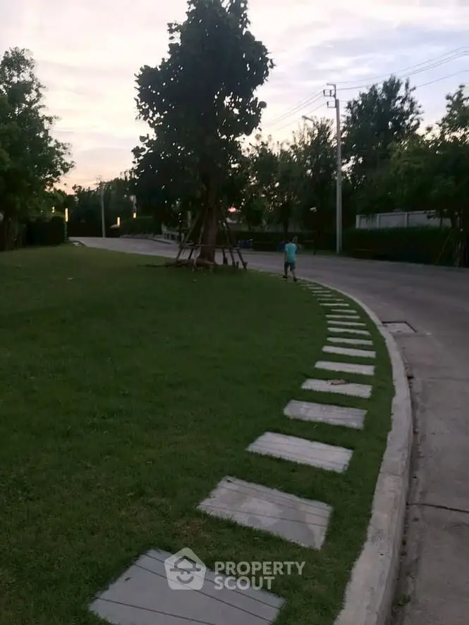 Charming suburban street with lush greenery and a serene pathway.
