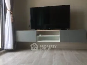 Modern living room with sleek TV unit and large window for natural light.
