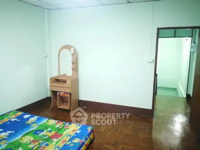 Simple bedroom with wooden floor and colorful mattress, ideal for minimalist living.