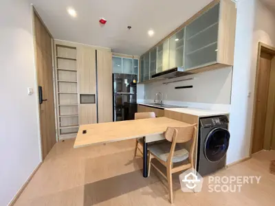 Modern kitchen with integrated appliances and wooden cabinetry in a stylish apartment.