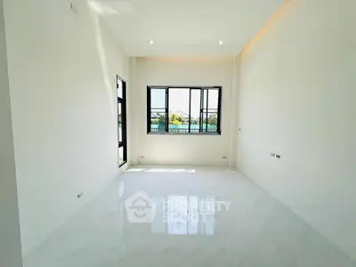 Spacious empty room with large window and marble flooring, perfect for customization.