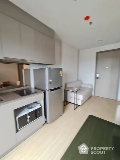 Modern kitchen with sleek cabinetry and stainless steel appliances in a cozy apartment.