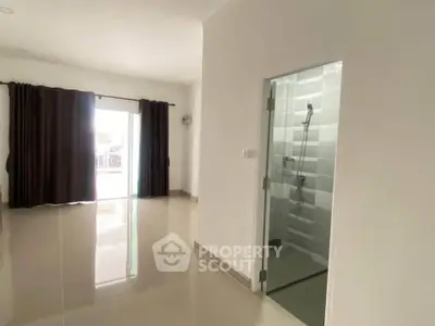 Spacious modern living room with glass shower enclosure and large windows.