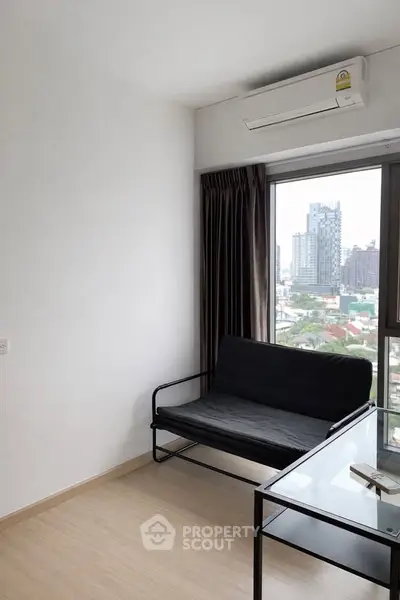 Modern apartment with city view, featuring sleek furniture and large windows.