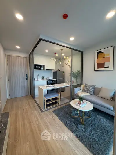 Modern living room with open kitchen, stylish decor, and cozy seating area in a contemporary apartment.