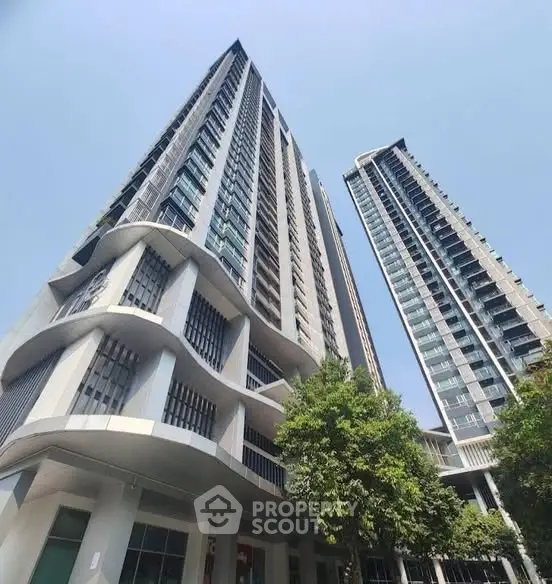 Stunning modern high-rise buildings with sleek architecture and lush greenery, perfect for urban living.