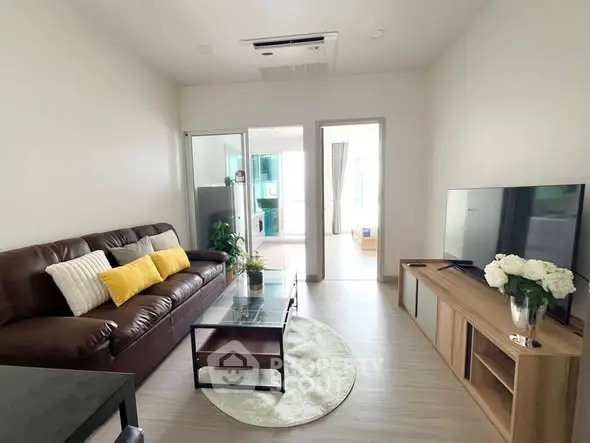 Modern living room with sleek furniture and natural light, perfect for relaxation and entertainment.