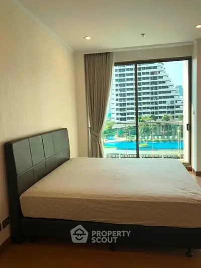 Spacious bedroom with pool view in modern apartment