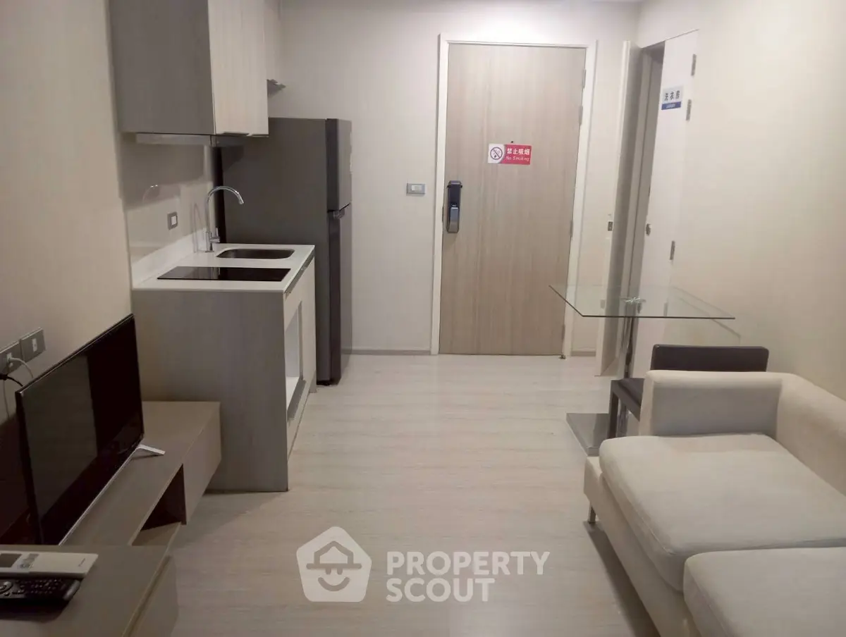 Modern compact living room with kitchenette and sleek furniture