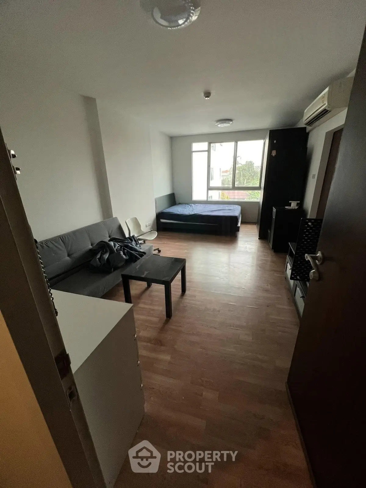 Spacious studio apartment with modern furnishings and large windows for natural light.