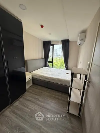 Modern bedroom with large window and stylish furnishings in a high-rise apartment.