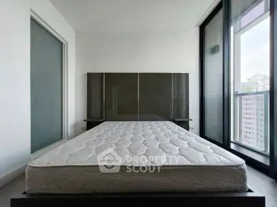 Spacious bedroom with large windows and modern design in a high-rise apartment.