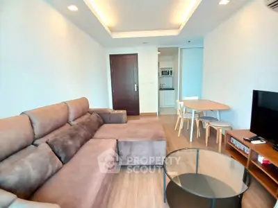 Modern living room with plush sofa and open kitchen layout