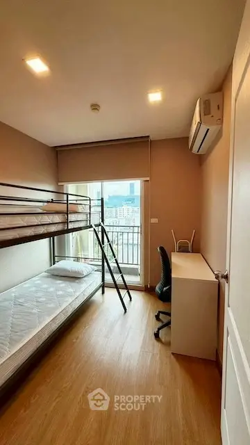 Compact bedroom with bunk bed, desk, and city view balcony.