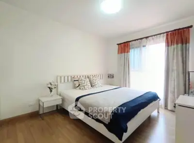 Bright and cozy bedroom with modern decor and large window for natural light.