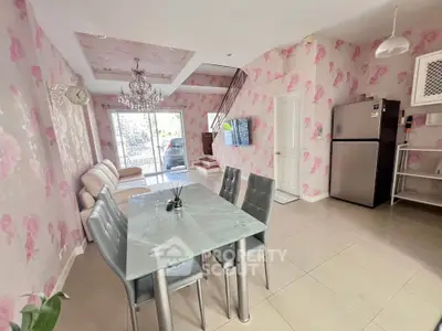 Charming open-plan living and dining area with floral wallpaper and modern furnishings.