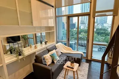 Modern living room with large windows and city view, featuring stylish decor and cozy seating area.