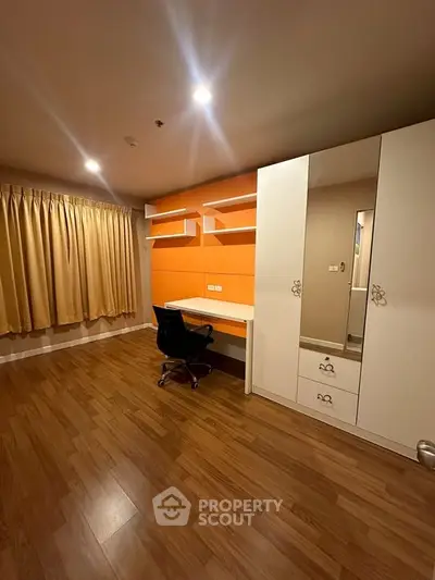 Spacious study room with modern desk and ample storage in a stylish apartment.
