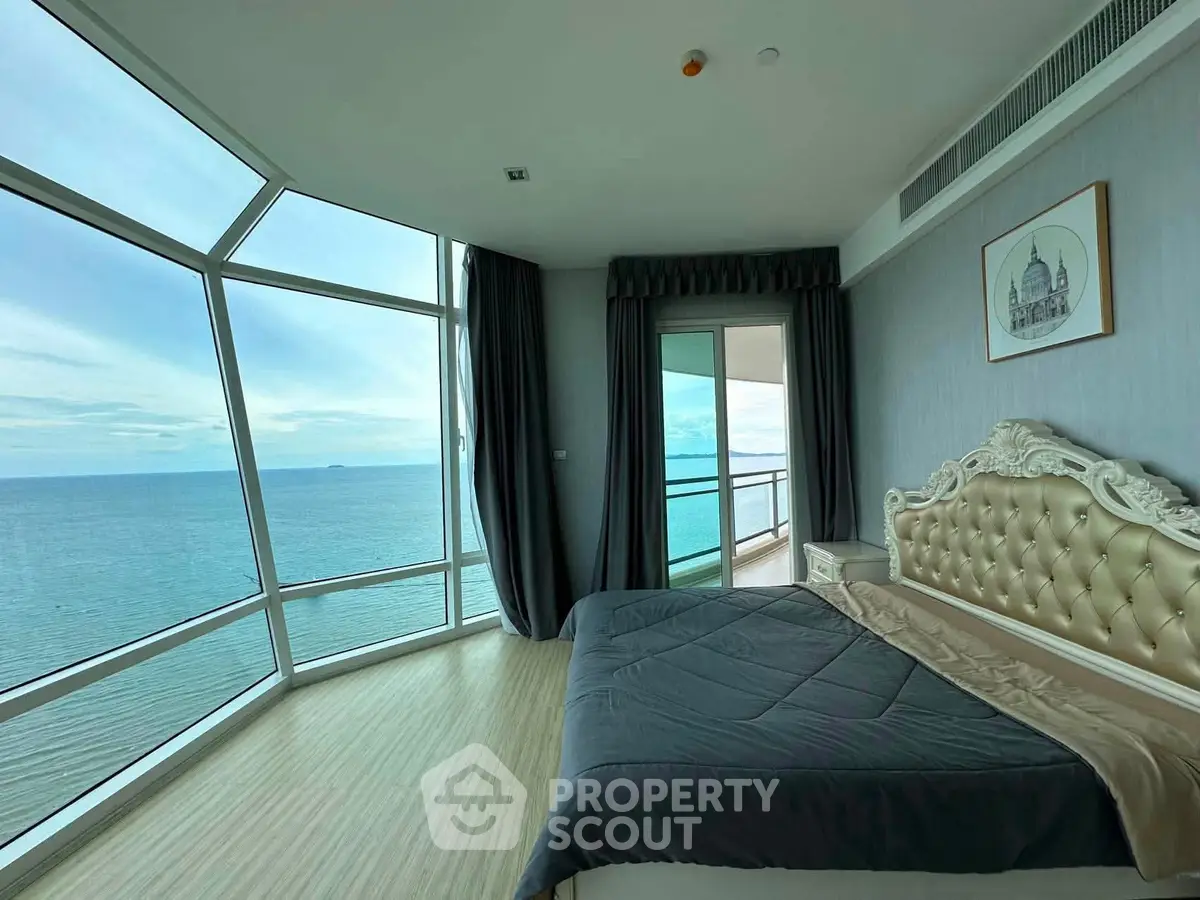 Luxurious bedroom with panoramic ocean view and elegant decor in high-rise apartment.
