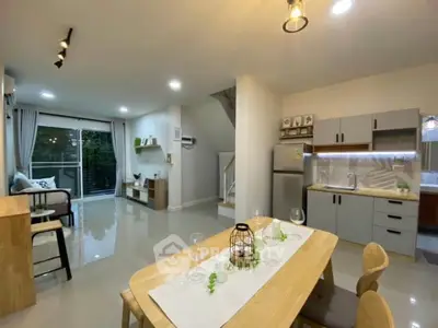 Modern open-plan living and dining area with sleek kitchen and large windows.