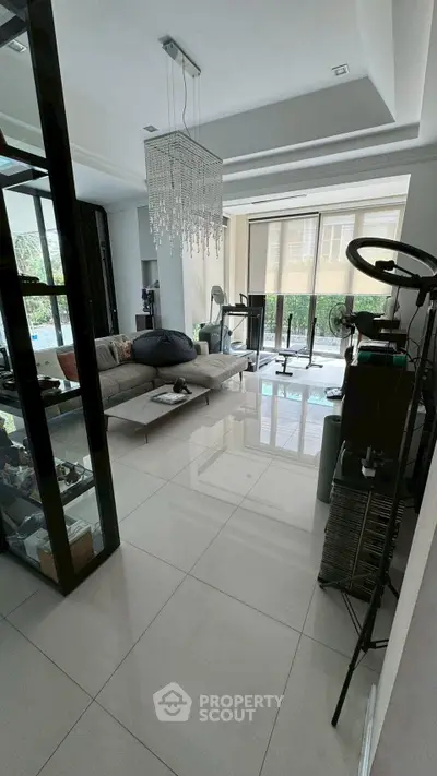 Spacious modern living room with elegant chandelier and large windows