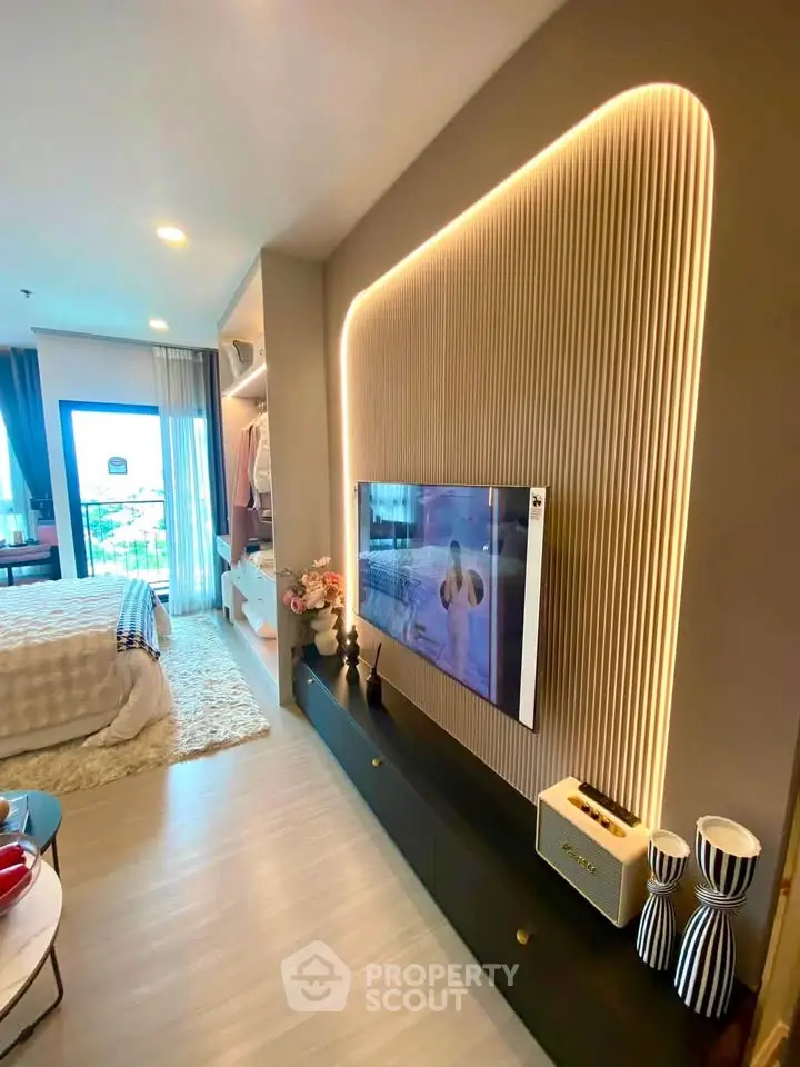 Modern living room with stylish TV wall and cozy bedroom view