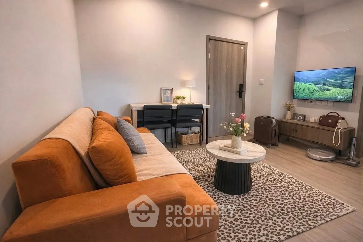 Modern living room with orange sofa, stylish decor, and wall-mounted TV