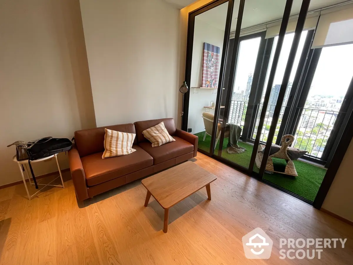 Inviting living room with sleek hardwood floors and modern furniture, leading to a sunny balcony with urban views.