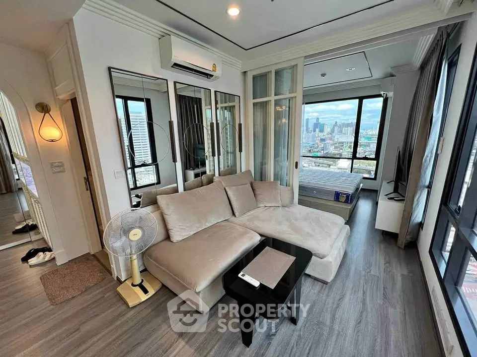 Modern living room with city view, featuring sleek furniture and stylish decor in a high-rise apartment.