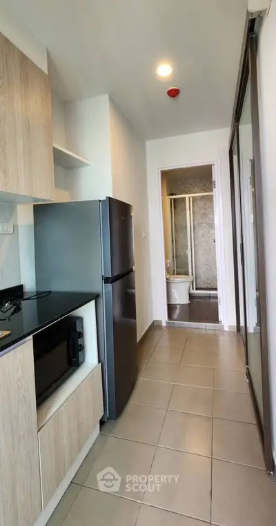 Modern kitchen with sleek appliances and a view into a stylish bathroom