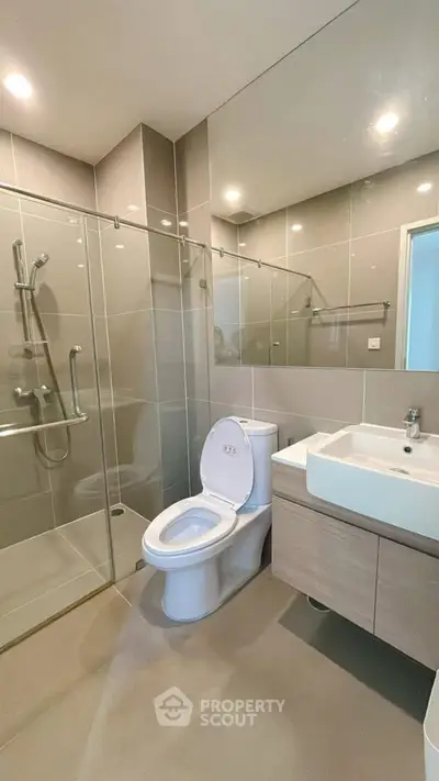 Modern bathroom with glass shower and sleek fixtures in a contemporary home.