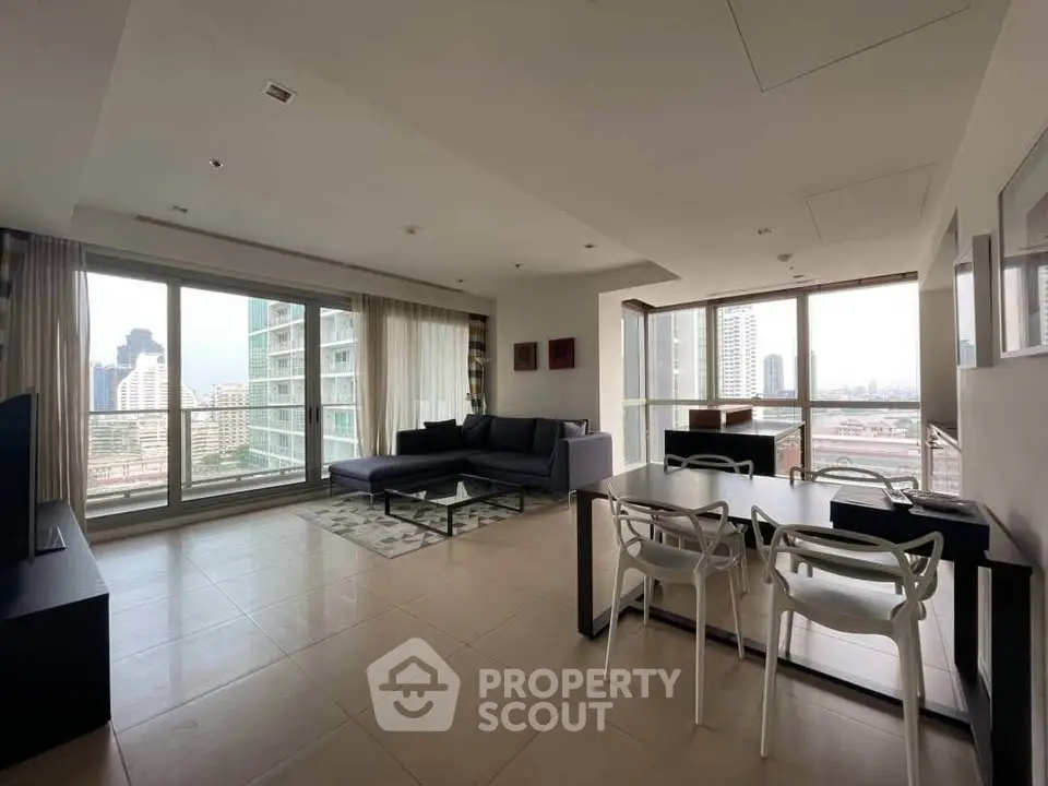 Spacious modern living room with panoramic city views and elegant dining area.