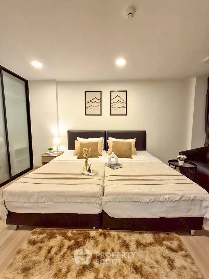 Spacious bedroom with twin beds, modern decor, and cozy lighting for a comfortable living experience.